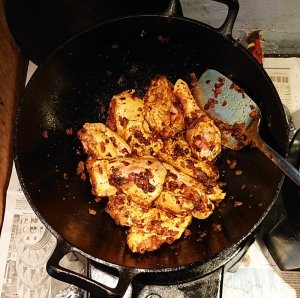 Chicken pieces in wok with masala and onions
