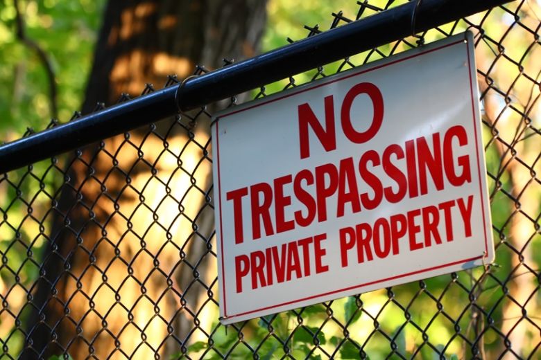 no trespassing sign on chainlink fence